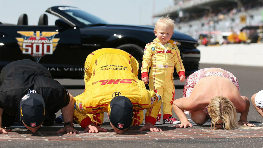 En gång i tiden var banan helt belagd med tegelstenar. I dag återstår en meter vid mållinjen, som segraren alltid kysser efter målgång. Här är det Ryan Hunter-Reay som firar sin seger 2014 tillsammans med fru Beccy och den lätt skeptiske sonen Ryden. FOTO: Chris Graythen/Getty Images