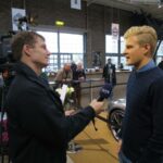 En man intervjuar en annan man om en bil. (AI text)