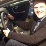 En man sittar i förarsätet i en bil. (AI text)