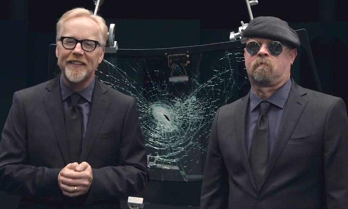 Två män i kostym står bredvid en bil. (AI text)