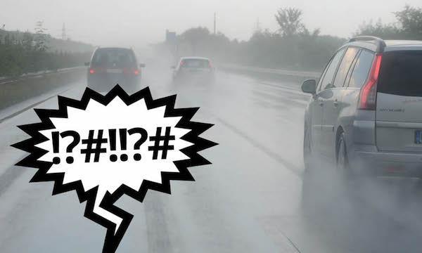 En bil kör nedför en väg med ett regndroppe över den. (AI text)