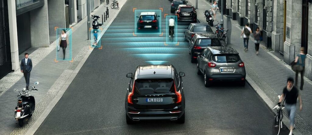 En bil kör nerför en stadsgata med cyklister på gatan. (AI text)