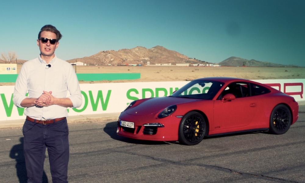 En man i solglasögon står bredvid en röd Porsche 911 GTS. (AI text)