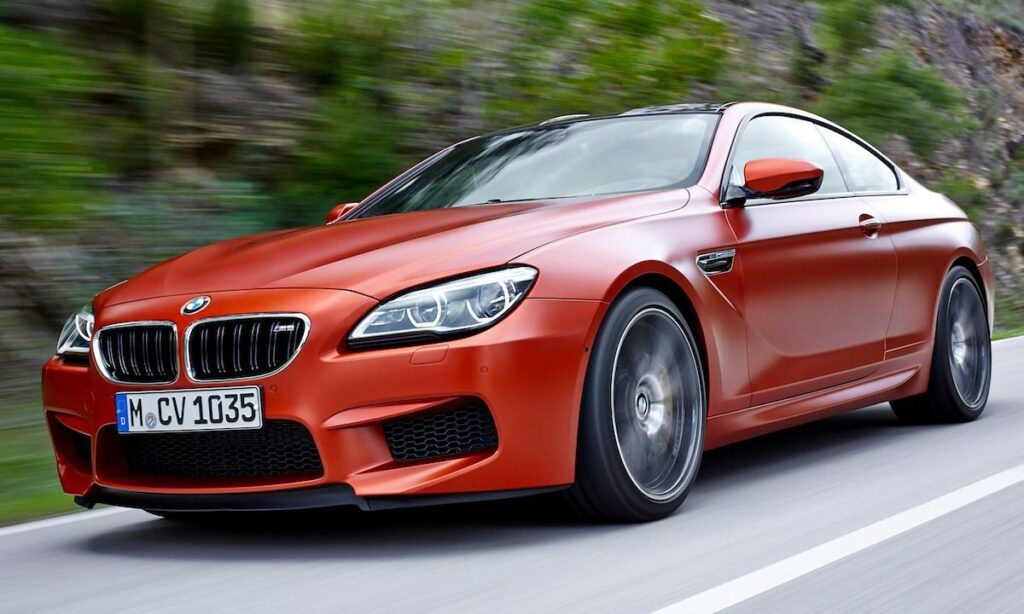 BMW M6 coupén kör nerför en bergsväg. (AI text)