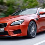BMW M6 coupén kör nerför en bergsväg. (AI text)