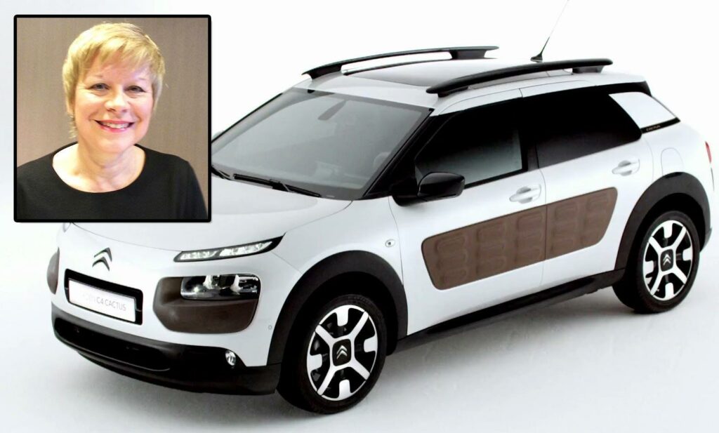 En kvinna står bredvid en bil. (AI text)