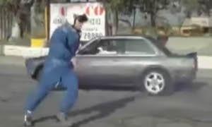 En man sparkar på en bil på gatan. (AI text)