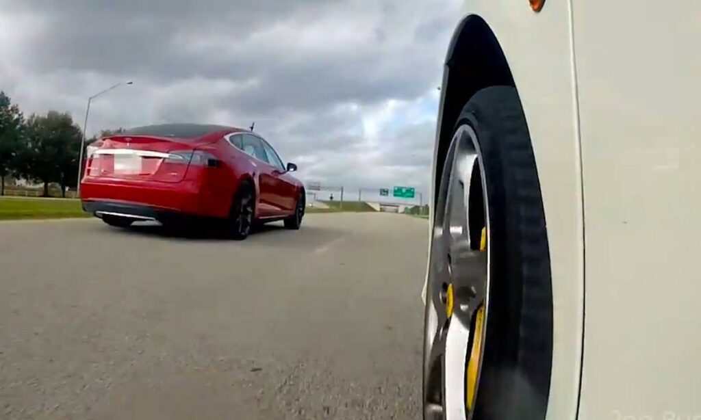 En Tesla Model S kör nerför vägen. (AI text)