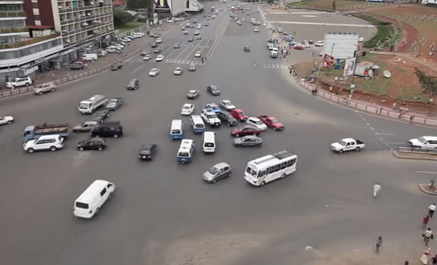 luftbild av en stadsgata med bilar och folk (AI text)