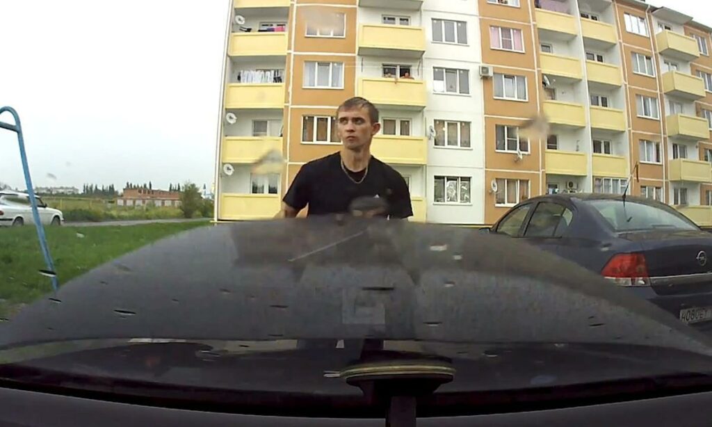 En man står framför en bil. (AI text)