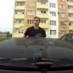 En man står framför en bil. (AI text)