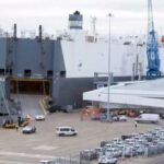 En stor containerskippa ligger förtöjd vid en kaj. (AI text)