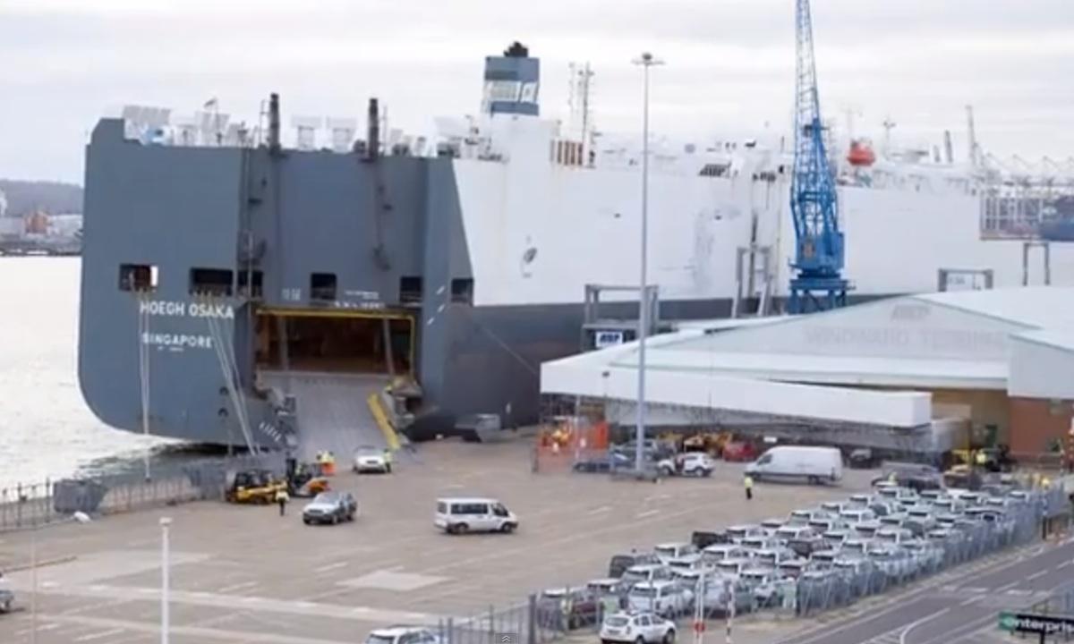 En stor containerskippa ligger förtöjd vid en kaj. (AI text)