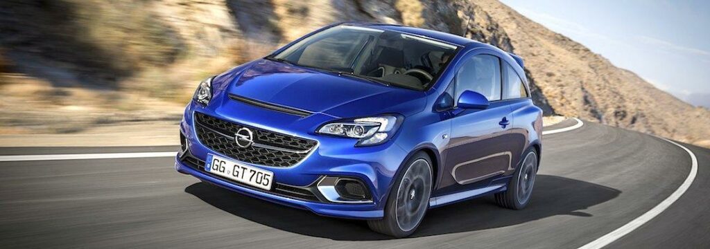 En blå Opel Astra kör nerför en bergsväg. (AI text)