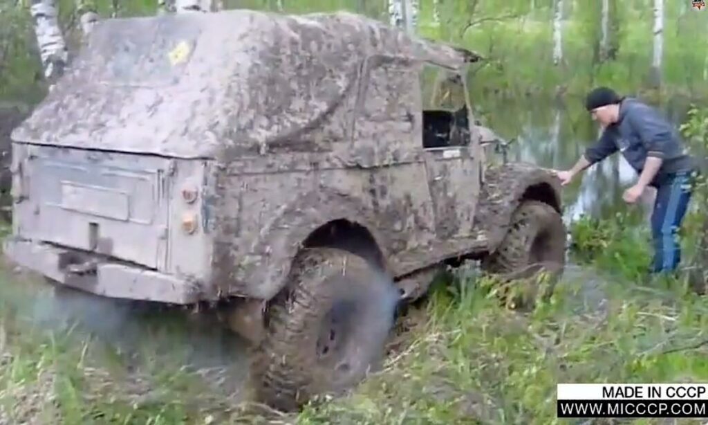 En man står bredvid en smutsig bil. (AI text)