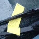 En bil med en gul parkeringskvitto på förarätten. (AI text)