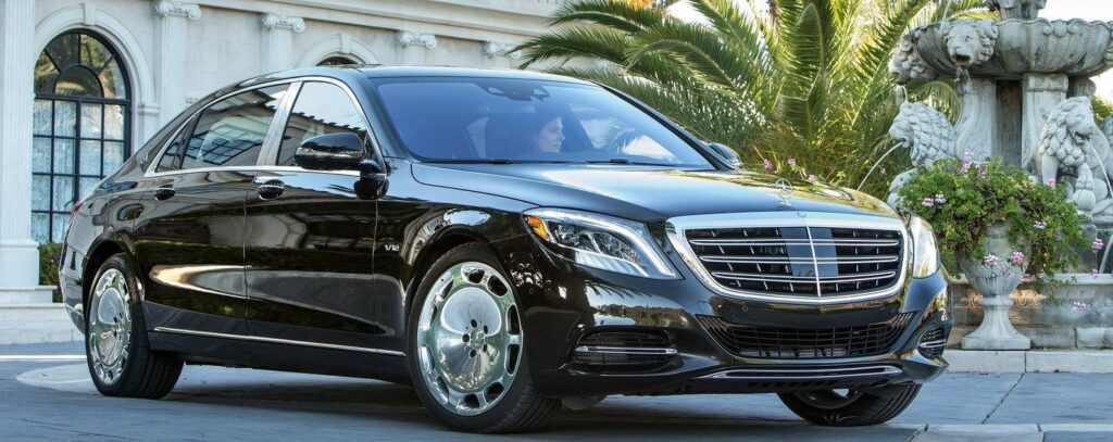 En Mercedes-Benz S-class parkerad framför ett hotell. (AI text)