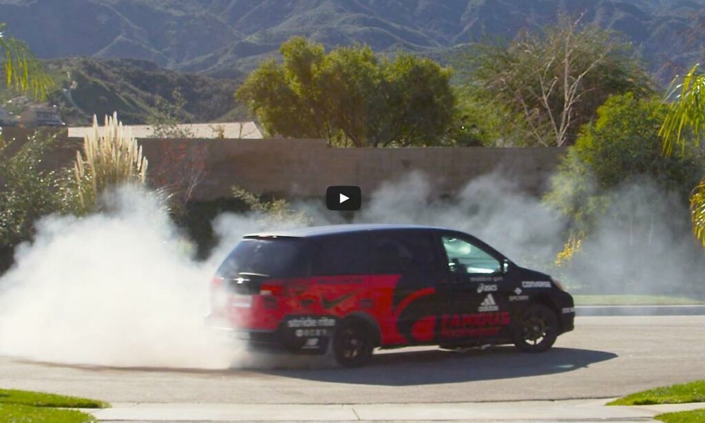 En Mercedes-van kör nedför en gata med rök som kommer ut ifrån den. (AI text)