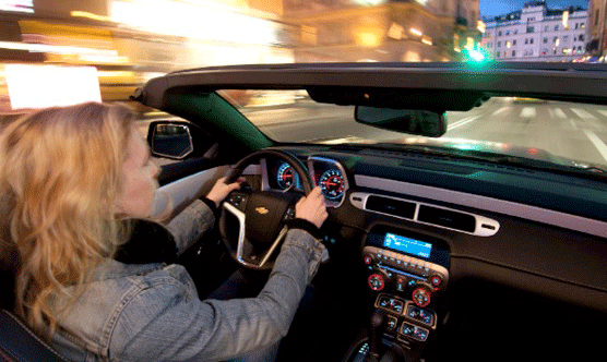 En kvinna kör en cabrioletbil på natten. (AI text)