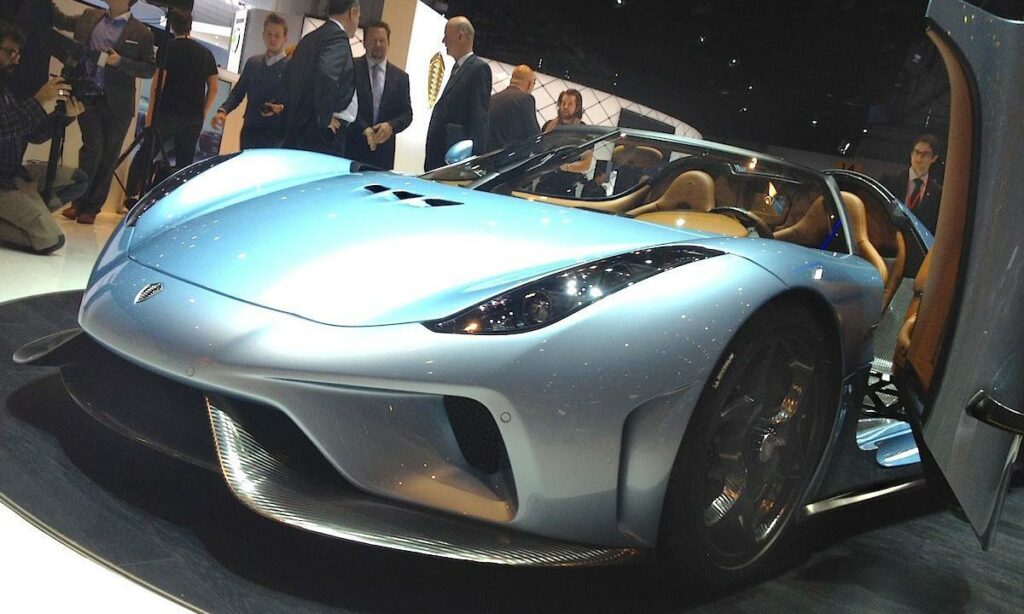 En man står bredvid en blå sportbil. (AI text)