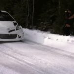 En bil kör genom en snöig väg. (AI text)