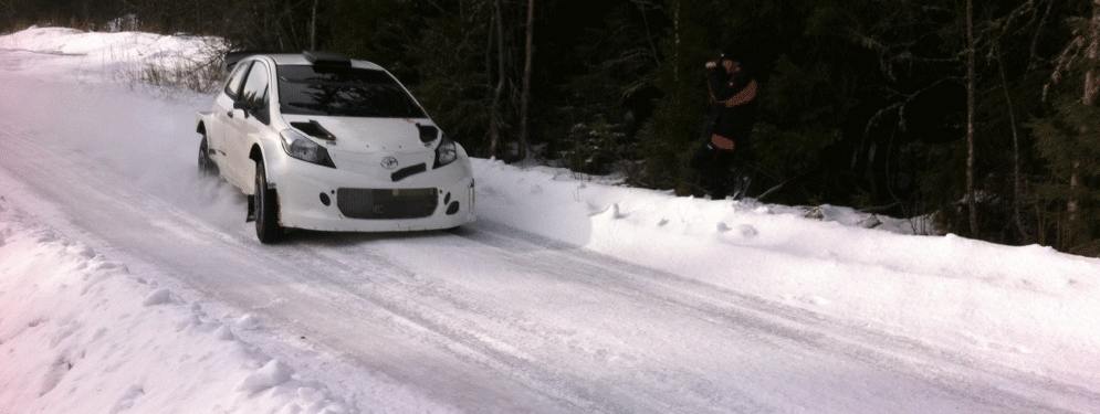 En bil kör genom en snöig väg. (AI text)