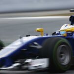 En blå Formel 1-bil kör på en bana. (AI text)