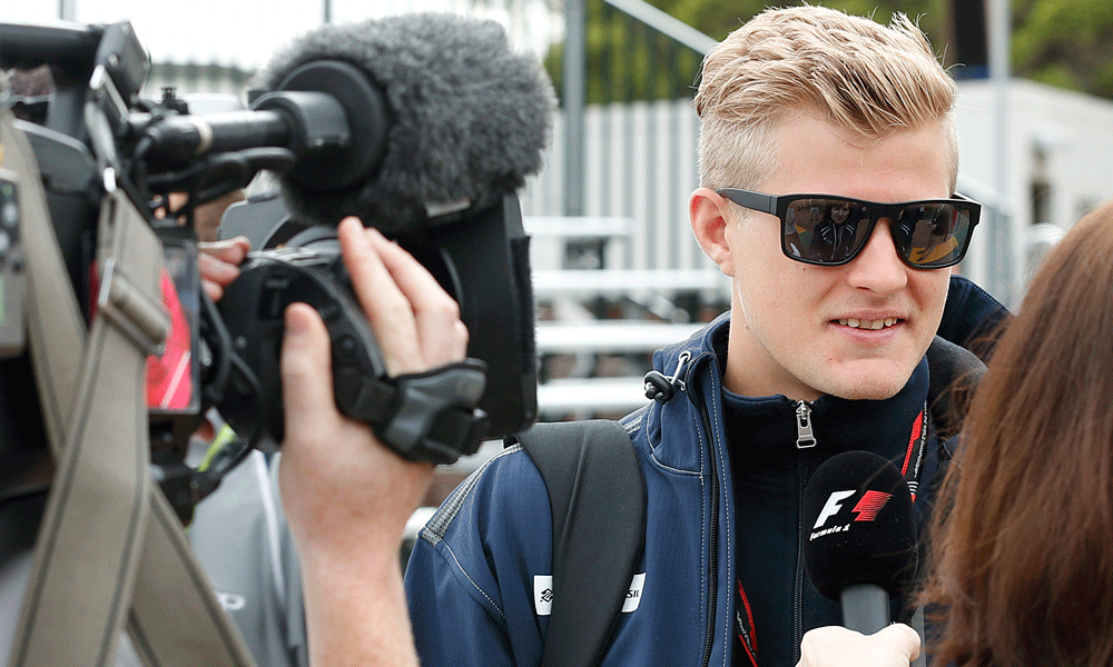 En racerförare intervjuas av reportrar. (AI text)