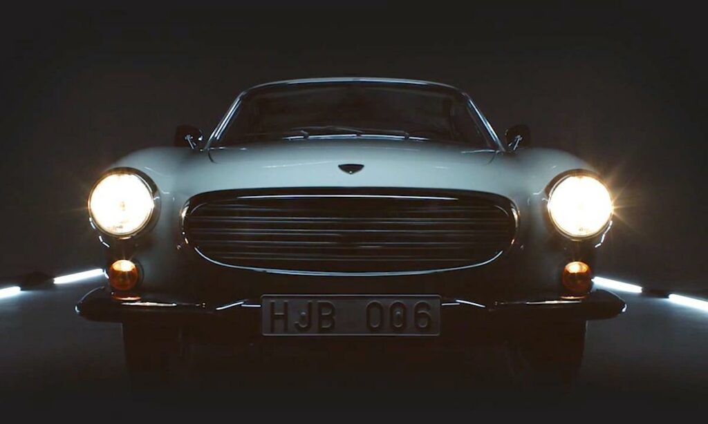 En klassisk bil i en mörk rum med lampor som lyser. (AI text)