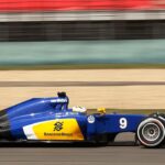 En blå och vit racerbil på en bana. (AI text)