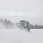 En traktor kör genom snön. (AI text)