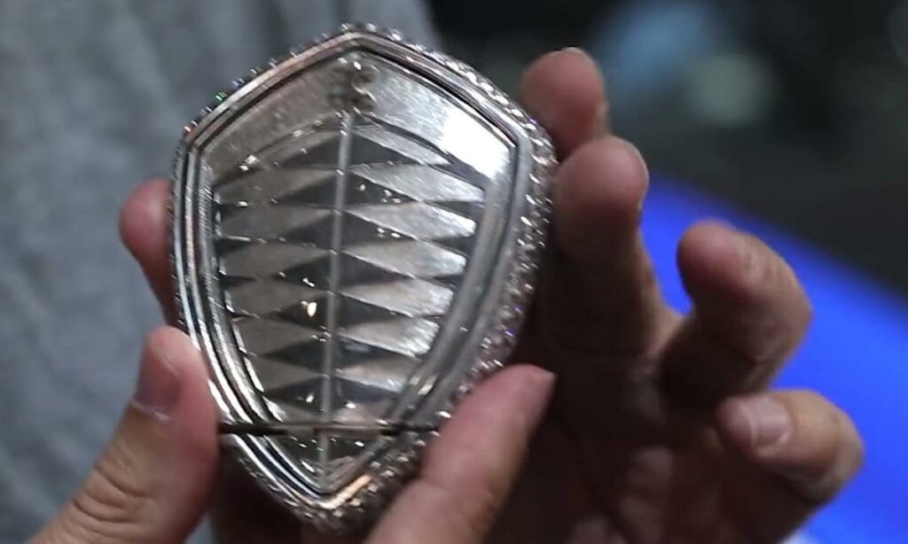 En man håller upp en silverring. (AI text)