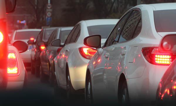 En bil i trafiken på en livlig gata. (AI text)