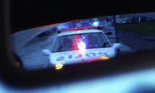 En polisbil syns i backspegeln. (AI text)