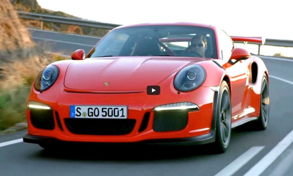 Porsche 911 GTS RS kör nedför en bergväg. (AI text)