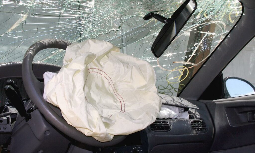 en bil med ett spräckt vindrughöl och en bältesbultning (AI text)