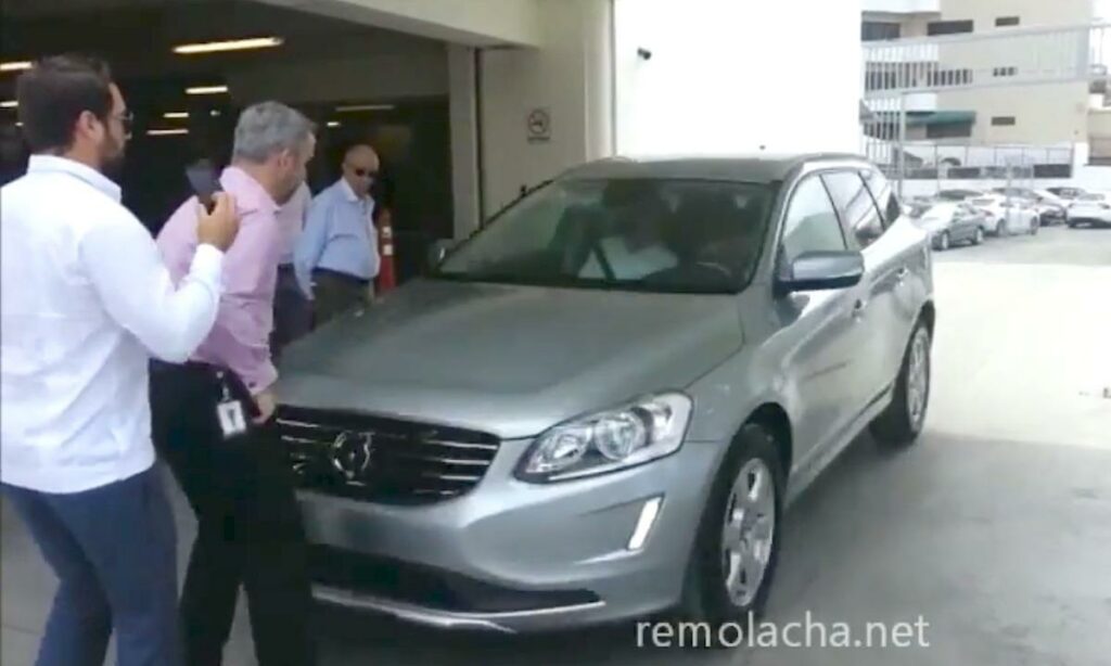 En grupp personer står bredvid en bil. (AI text)