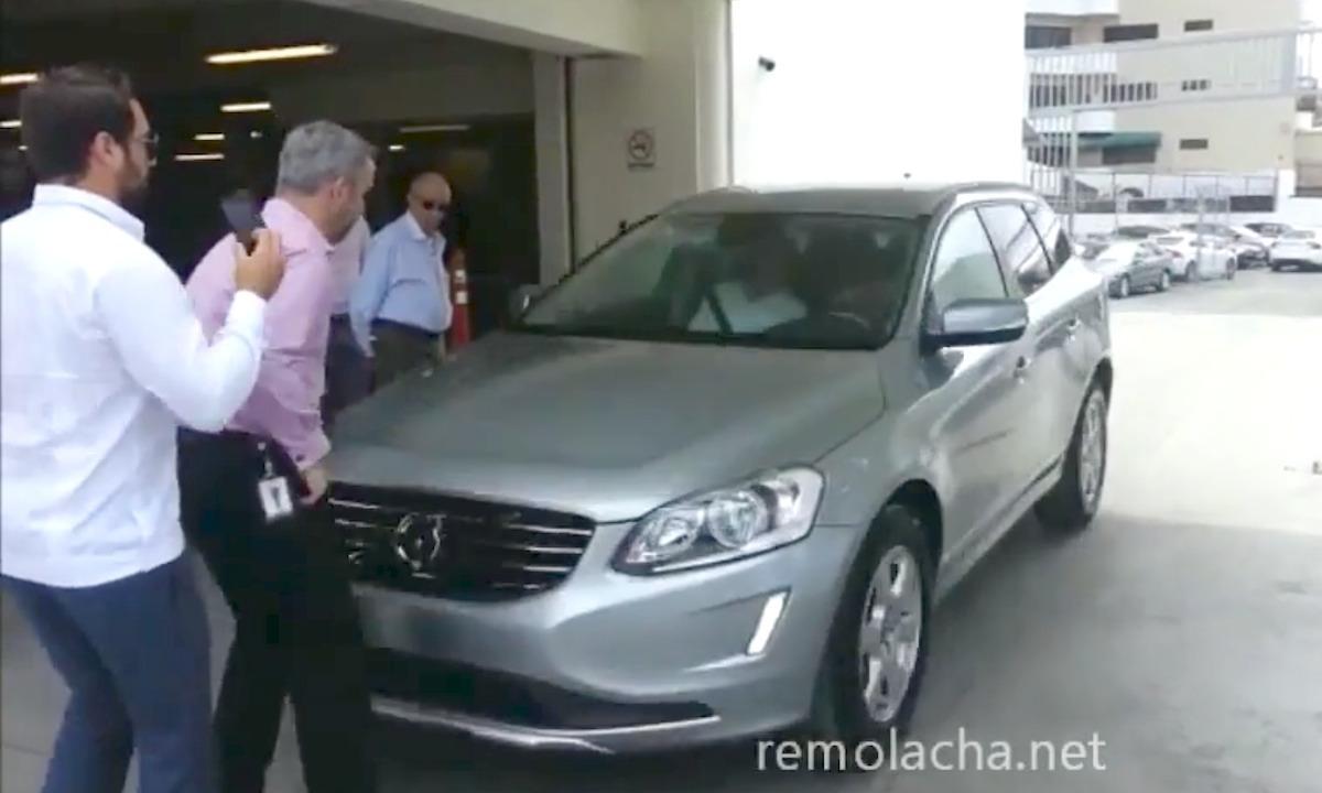 En grupp personer står bredvid en bil. (AI text)