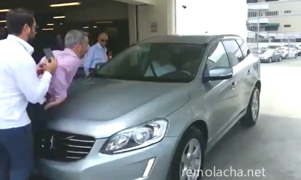 En man kliver upp i en bil. (AI text)