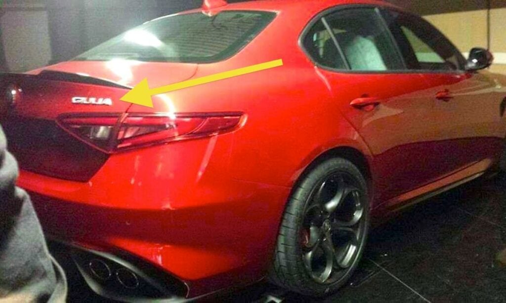 En röd Alfa Romeo GT står parkerad i ett garage. (AI text)