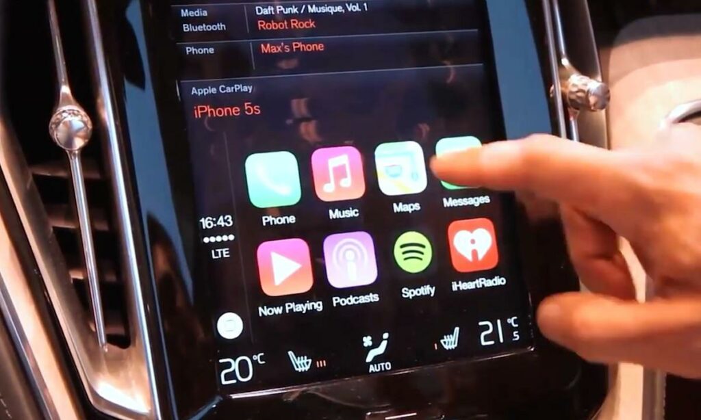En person använder skärmen i en bil. (AI text)