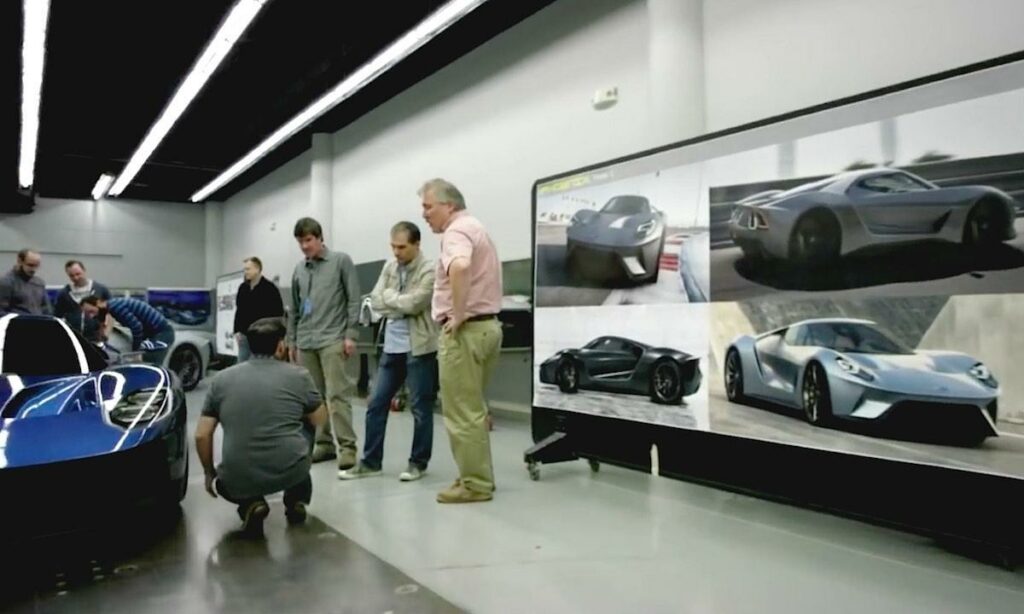 En grupp personer tittar på en bil. (AI text)