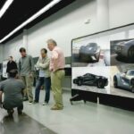 En grupp personer tittar på en bil. (AI text)