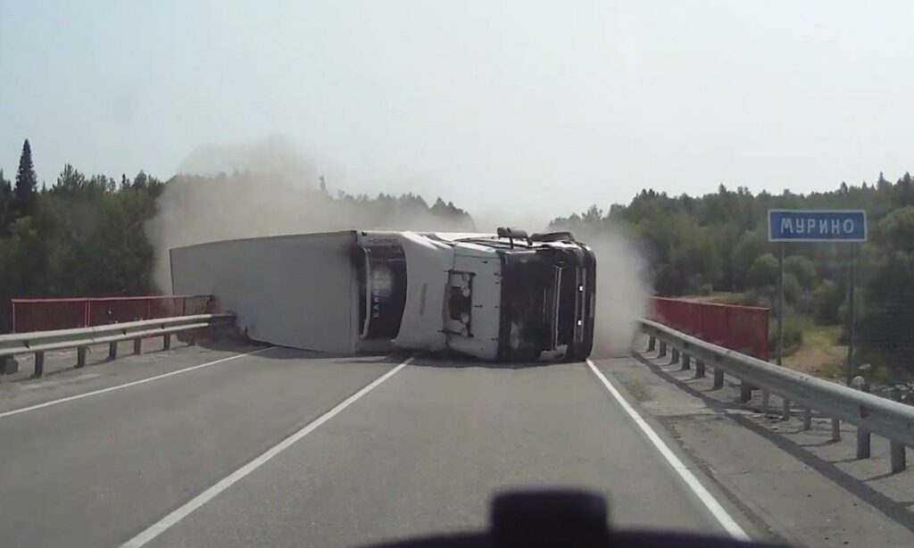 En lastbil ligger uppåt på en motorväg. (AI text)