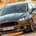 En Ford Mondeo kör nedför en landsväg. (AI text)