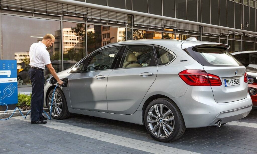 BMW I3 E30-pluggade hybridelektriska bilen laddar på en laddstation. (AI text)