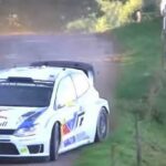 En Volkswagen Polo rallybil kör nedför en grusväg. (AI text)