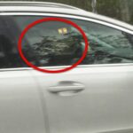 En bil med ett rött cirkel i fönstret. (AI text)