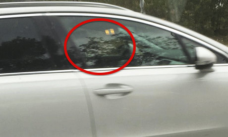 En bil med ett rött cirkel i fönstret. (AI text)