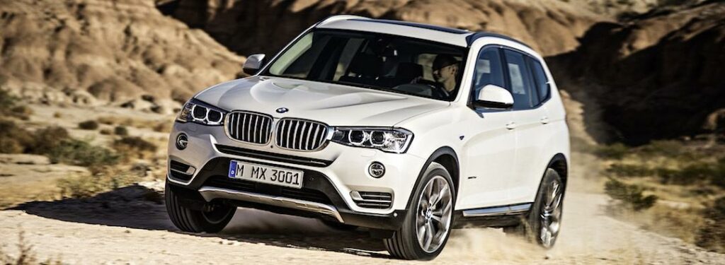 BMW X3 kör på en grusväg (AI text)